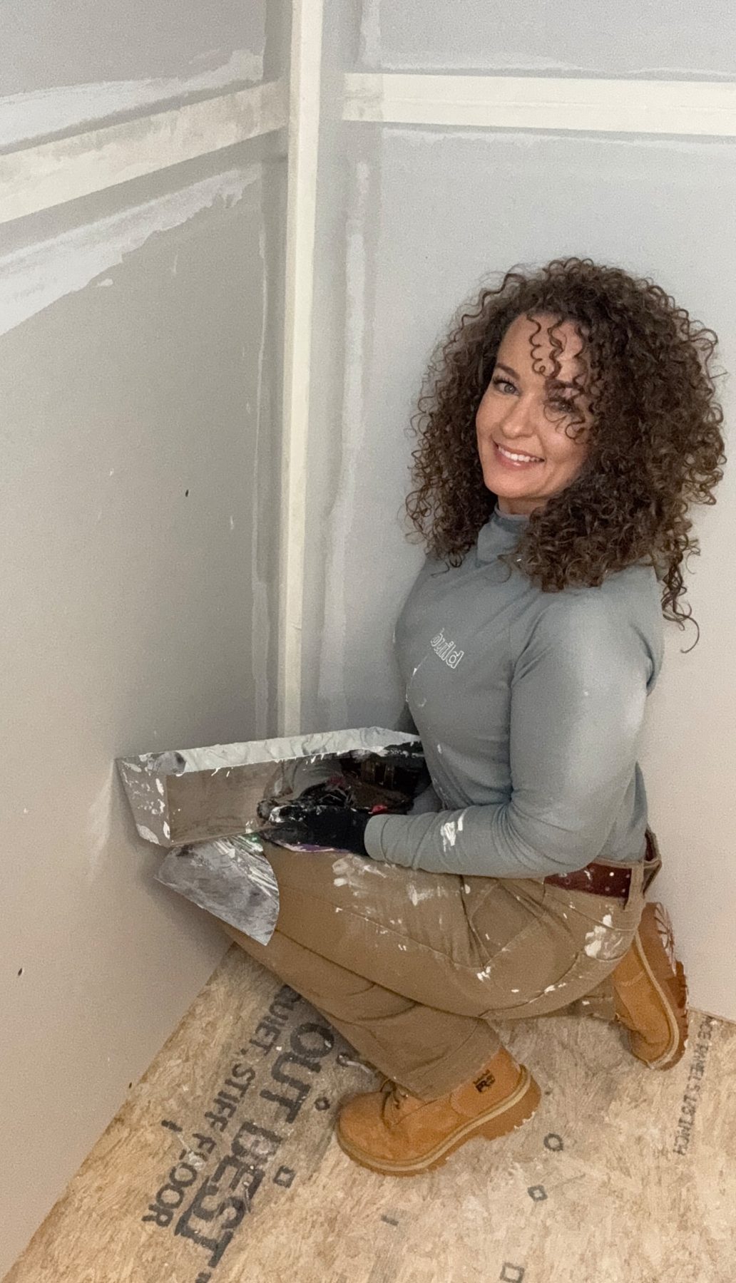 Lydia finishing an inside corner with a mud pan