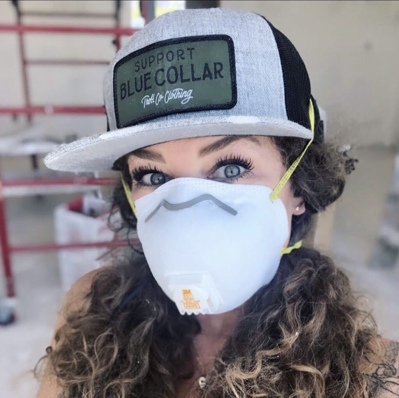 Lydia in a Support Blue Collar hat and dust mask