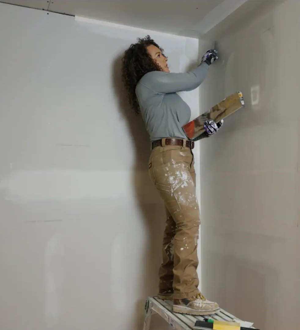 Lydia taping a ceiling corner